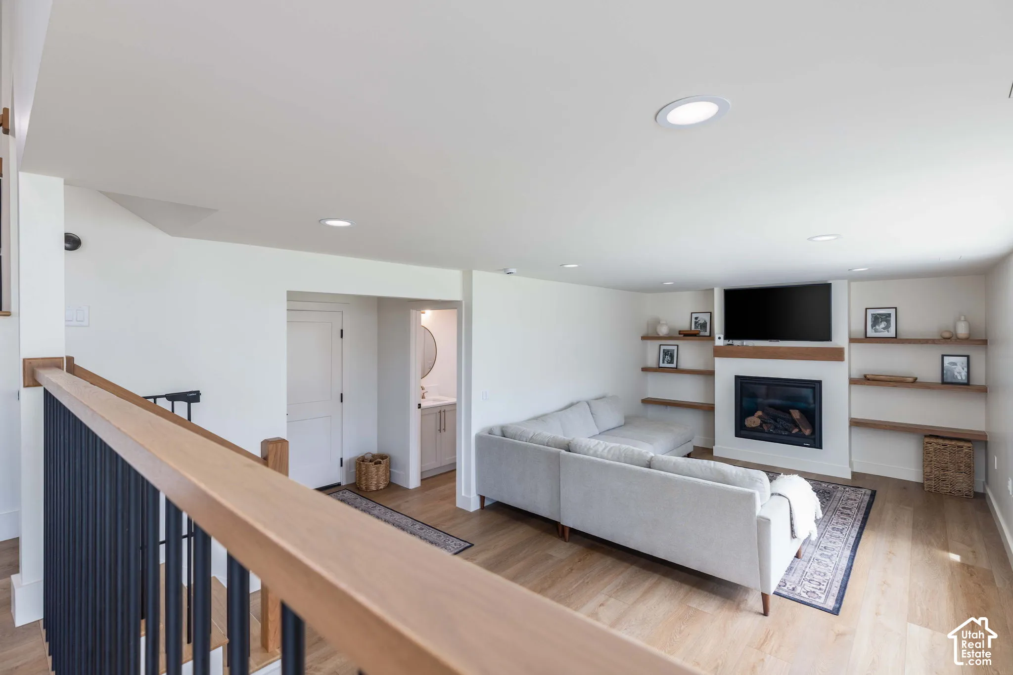 Recreational room featuring a fireplace with a wood mantle and integrated shelving