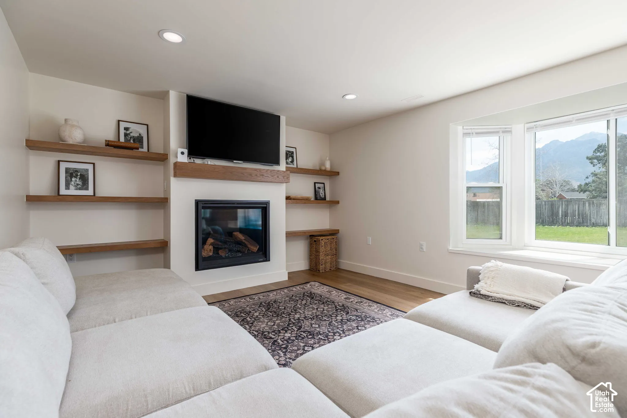 Living area with a built-in fireplace, mantle, and recessed lighting