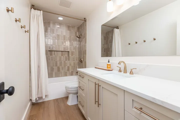 Bathroom with a single vanity, undermount sink, and light-toned cabinetry