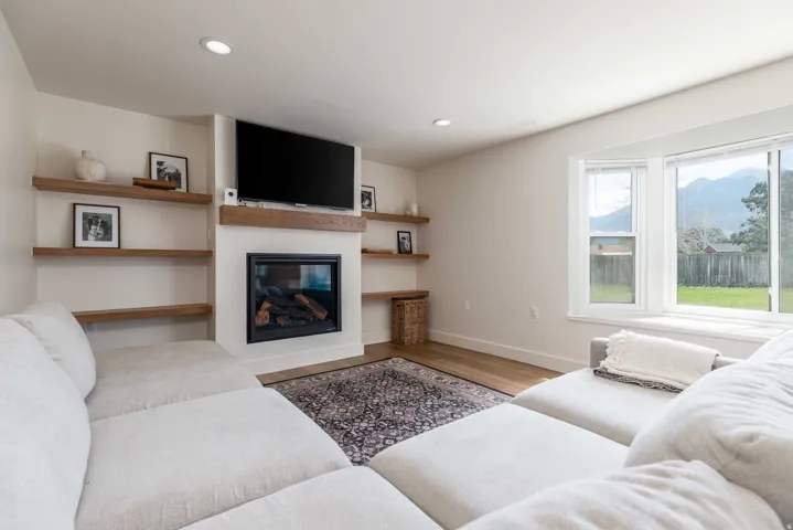 Living area with a built-in fireplace, mantle, and recessed lighting