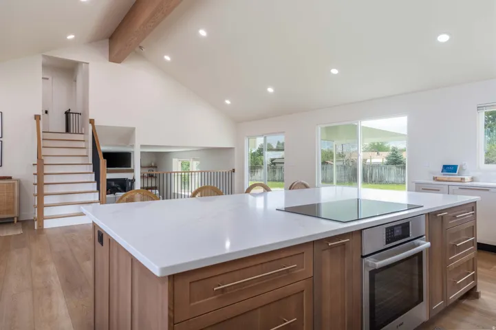 Kitchen island with a light-toned countertop, integrated induction cooktop, and built-in oven