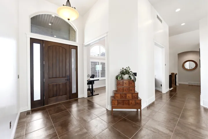 Entryway featuring a dark wood front door with side lites and an arched transom window