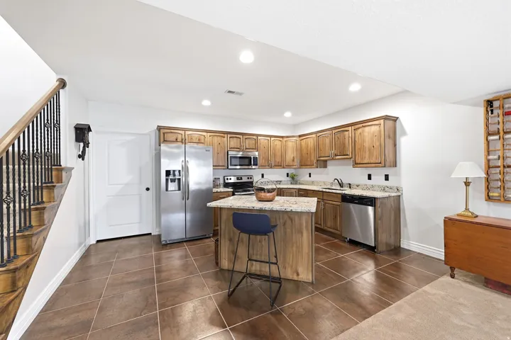 Kitchen with wood-finish cabinetry, granite countertops, and stainless steel appliances