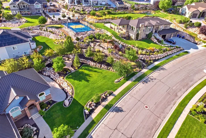 Extensive terraced landscaping featuring rock retaining walls, mature trees, and shrubs