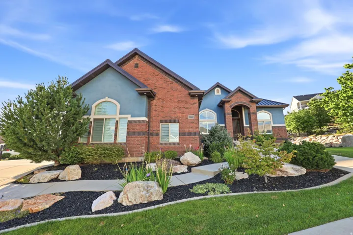 Brick and stucco exterior featuring a covered entry and arched windows