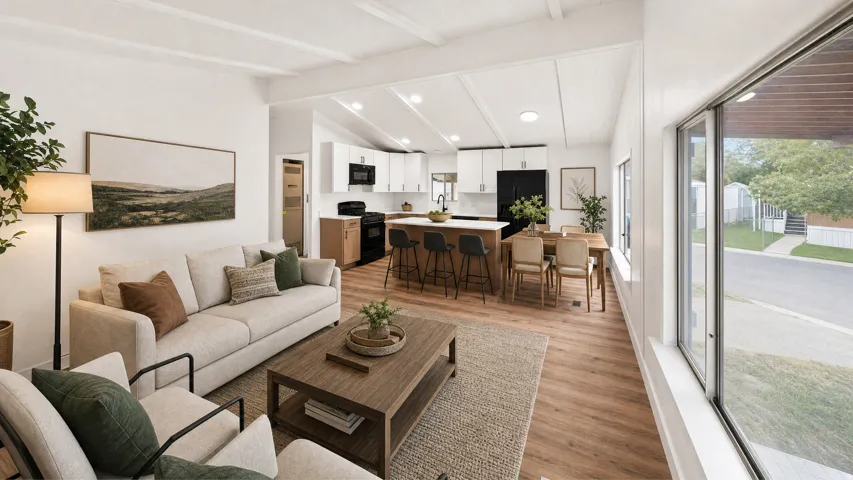 Open-concept living space featuring wood-finish flooring, vaulted ceilings, and large windows