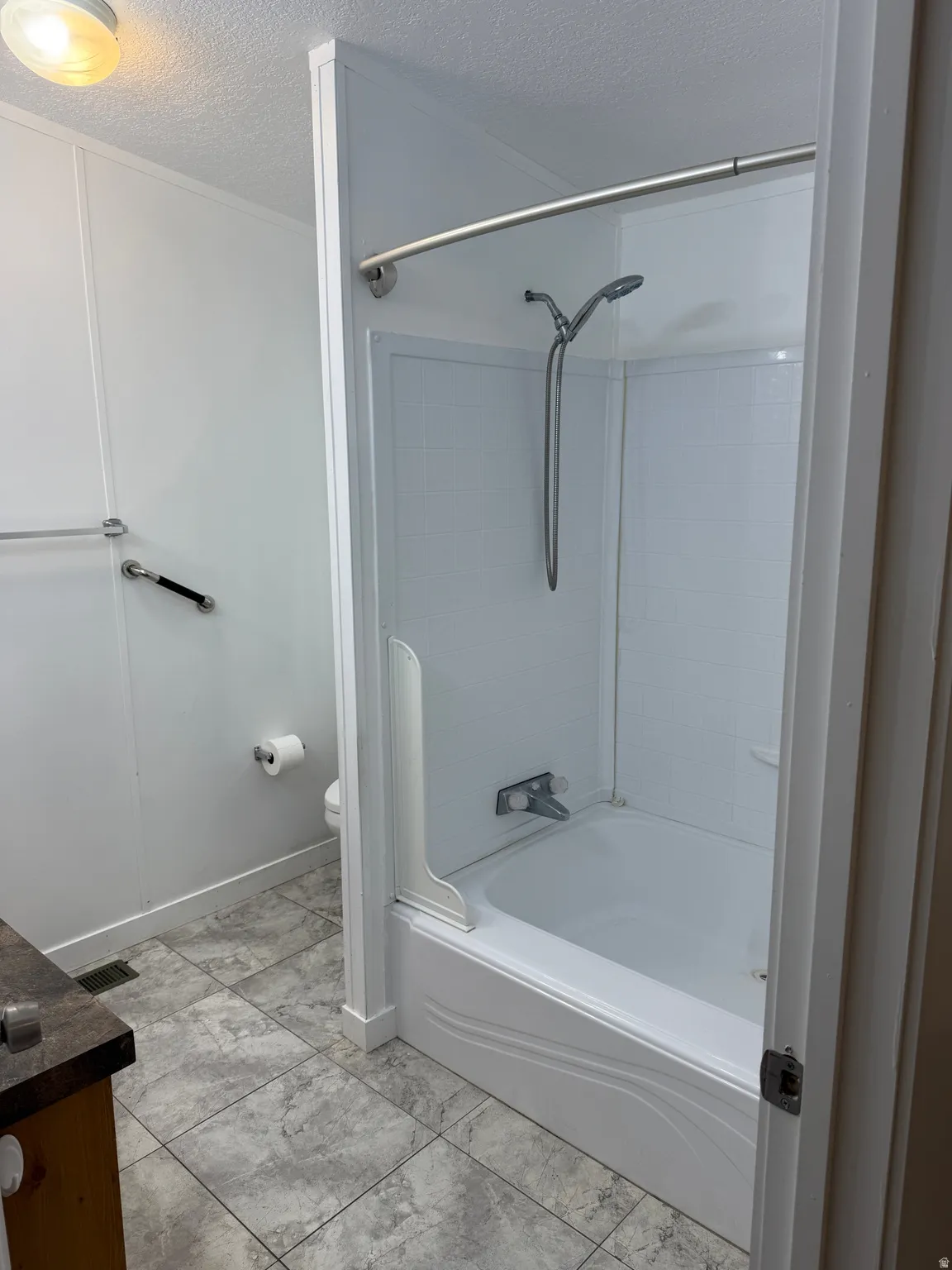 White acrylic tub and shower combination with a curved shower rod