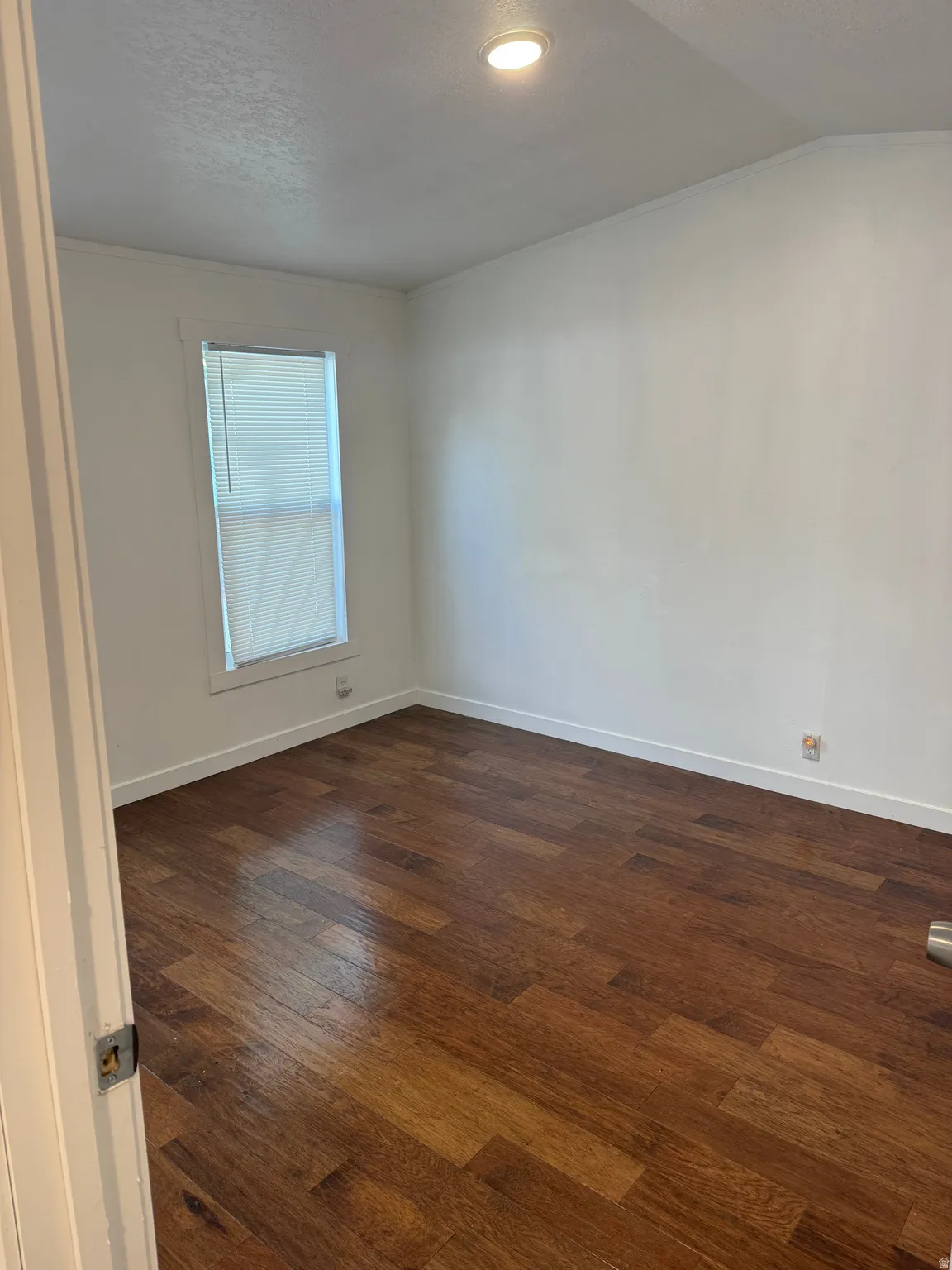 Room featuring wood-finish flooring, white walls, and a recessed ceiling light