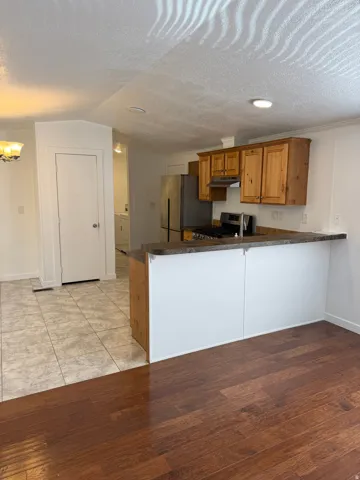 Kitchen area featuring wood cabinetry, stainless steel appliances, and a gas range