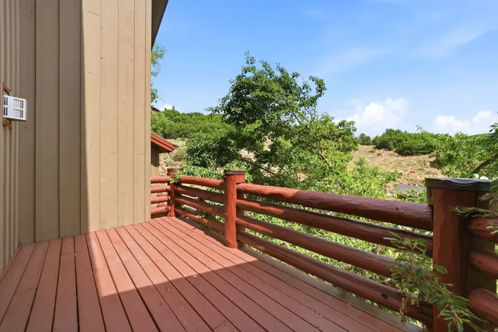 Outdoor deck with rich wood-finish flooring and a log-style railing