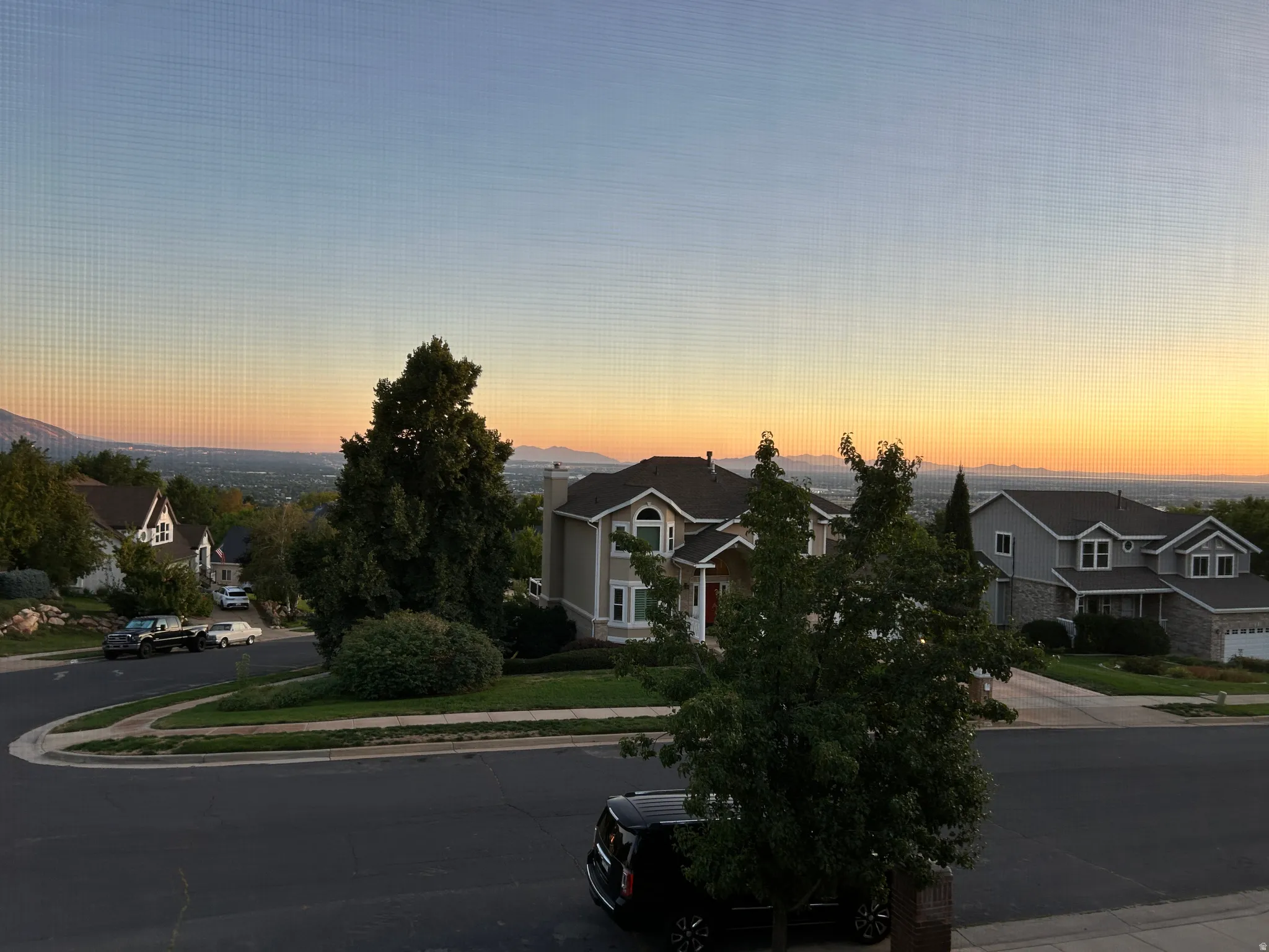 Expansive distant mountain range with a visible cityscape in the valley