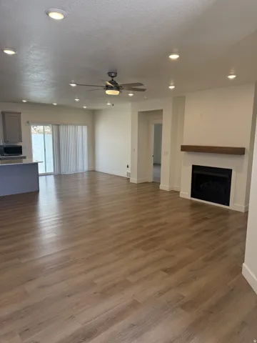 Open-concept living area featuring wood-finish flooring, recessed lighting, and a ceiling fan