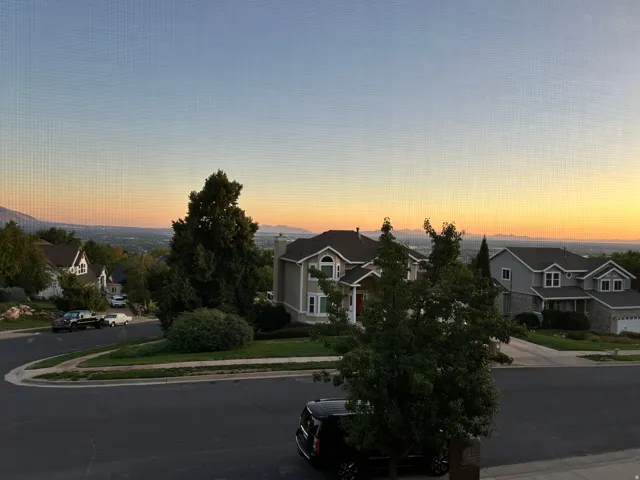 Expansive distant mountain range with a visible cityscape in the valley
