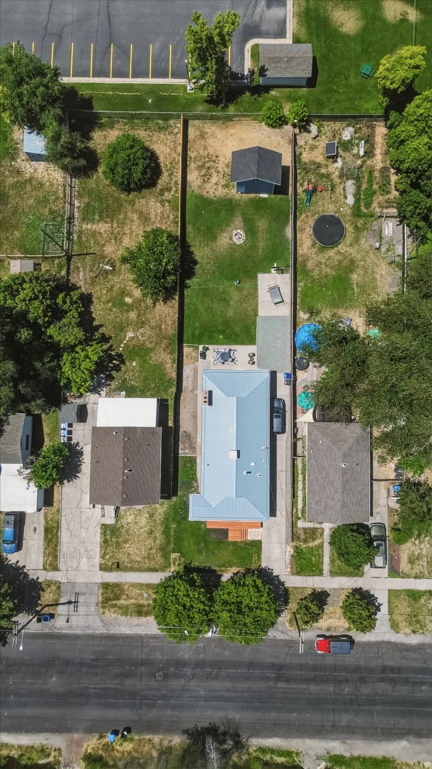 Single-story residence with a light gray metal roof and an extensive rear yard