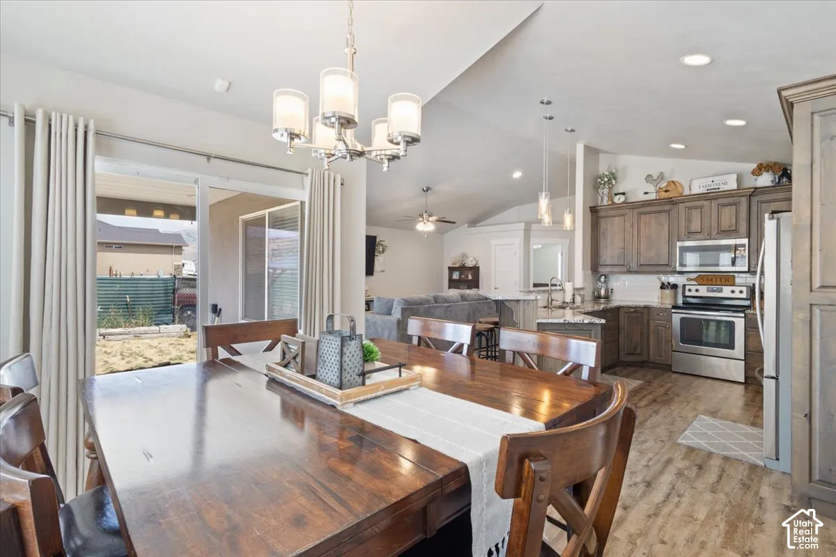 Dining area featuring wood-finish flooring, a contemporary chandelier, and direct patio access through sliding glass doors