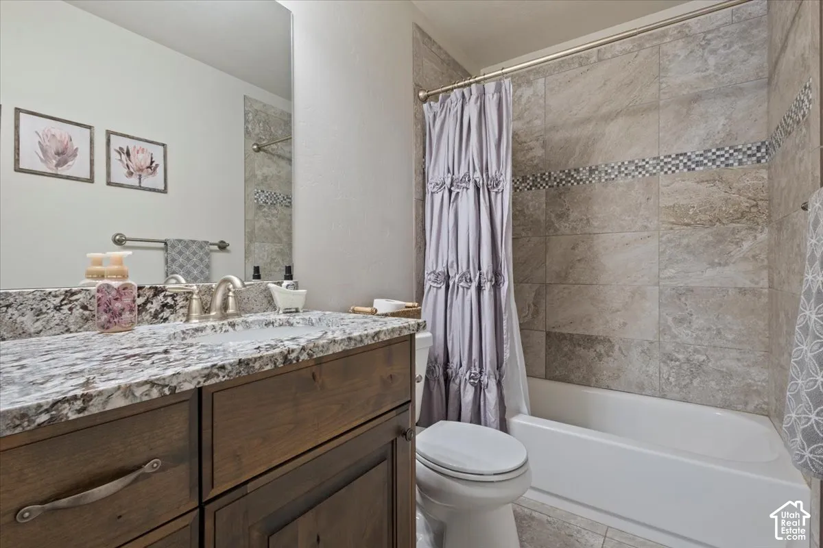 Bathroom featuring a wood-finish vanity with a granite countertop, undermount sink, and brushed nickel faucet