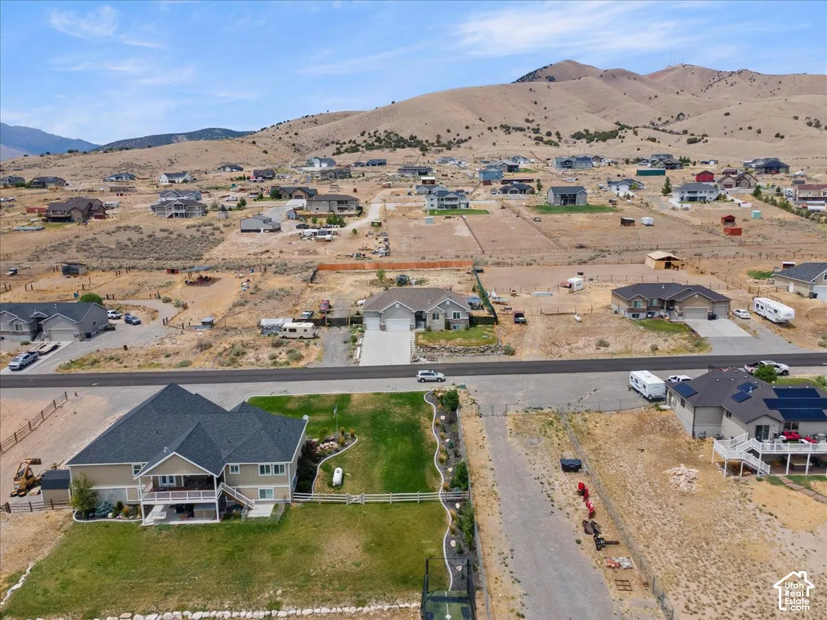 Spacious property with a multi-level deck and a large, manicured lawn, situated against a backdrop of rolling hills