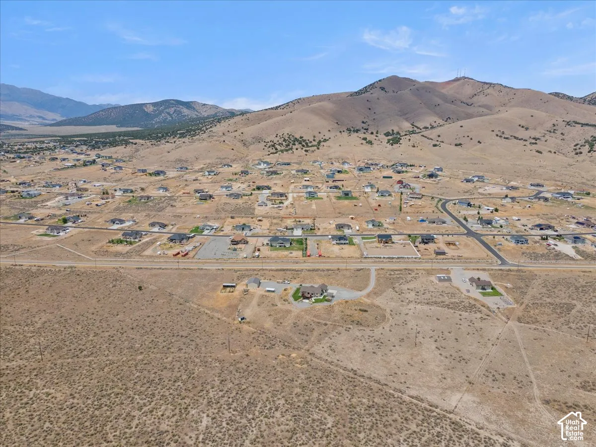 Expansive desert landscape featuring residential developments and mountainous backdrops