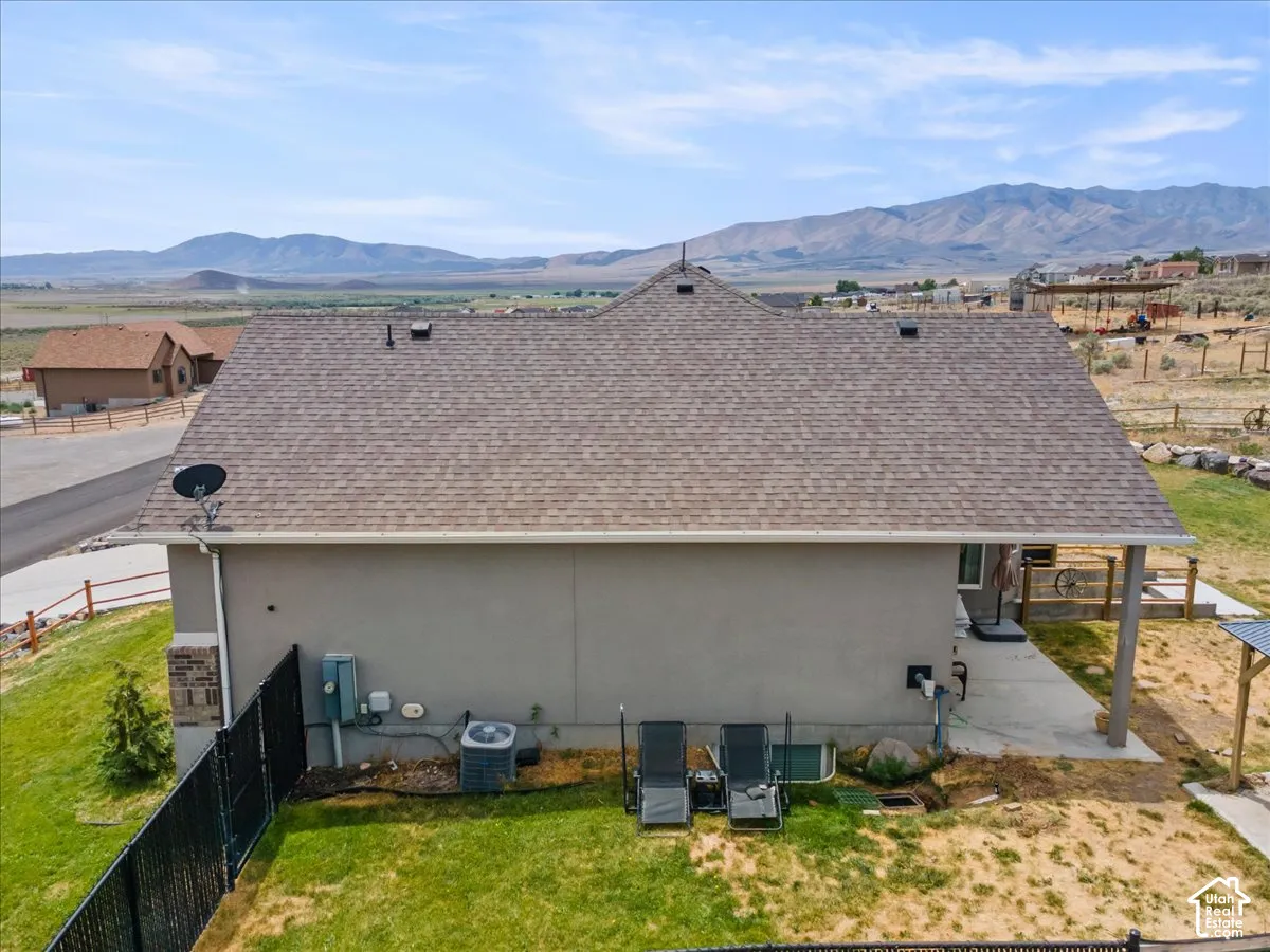 Rear exterior of residence featuring a shingle roof and stucco siding