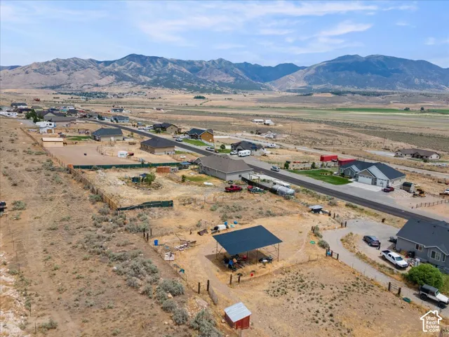 Expansive land parcel featuring a covered open-air structure, a small red shed, and a gravel driveway