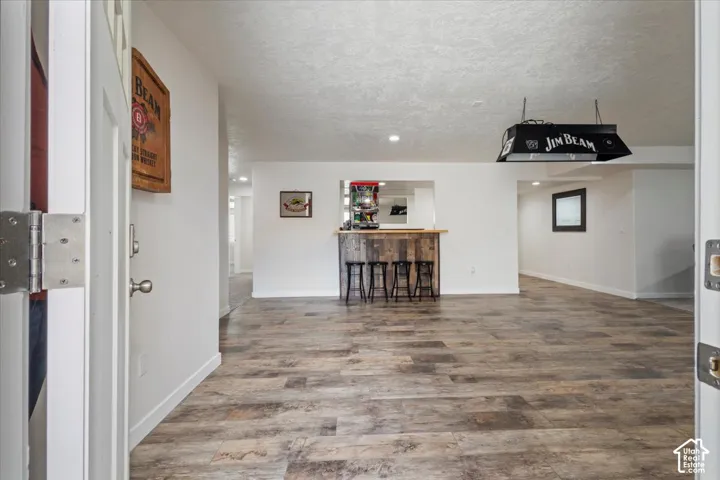 Spacious room featuring wood-finish flooring, white walls, and recessed lighting