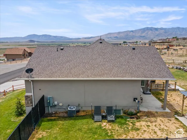 Rear exterior of residence featuring a shingle roof and stucco siding