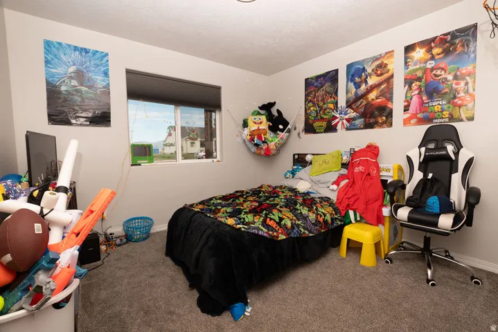 Carpeted room with a window featuring a cellular shade