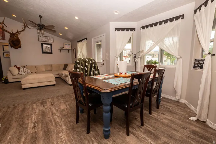 Wood-finish flooring throughout the dining area, featuring a bay window with multiple windows and recessed lighting