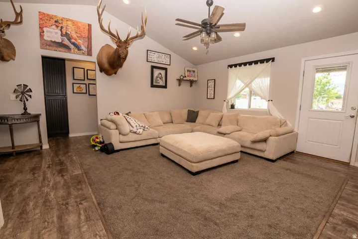 Spacious living area featuring a vaulted ceiling and wood-finish flooring