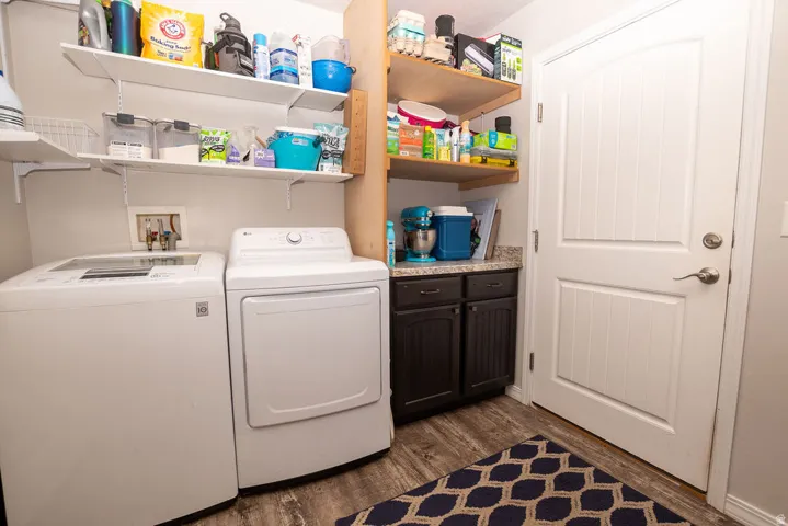 Dedicated laundry space featuring wood-finish flooring