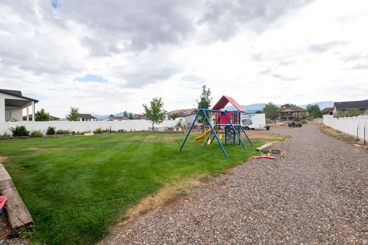 Expansive lawn area with a white privacy fence