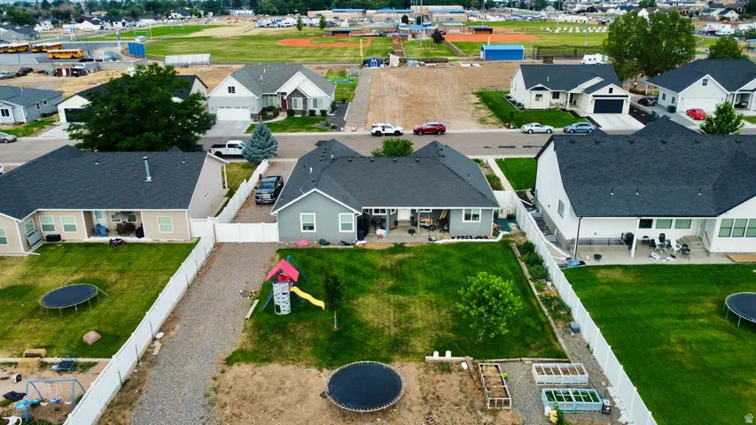 Aerial view showcasing a modern residential property with a dark shingle roof and light gray siding