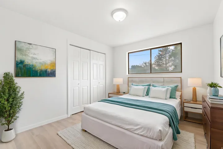 Bedroom featuring light wood-finish flooring and a horizontal window w/ virtual staging