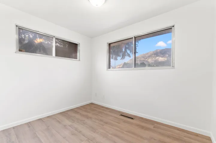 Interior space featuring wood-finish flooring, white baseboards, and white walls