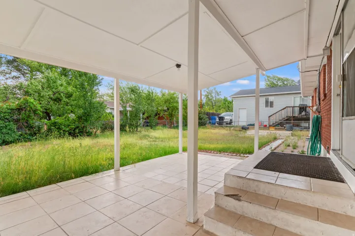 Covered patio featuring large format tile flooring and structural support columns