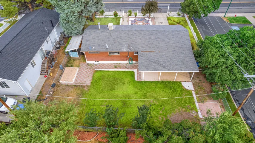 Expansive rear yard featuring a large covered patio, brick and paver patio areas, and a substantial lawn space