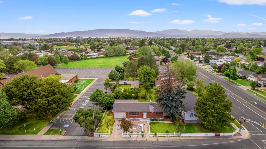 Single-story residence with a red brick facade and a white picket fence, set on a corner lot