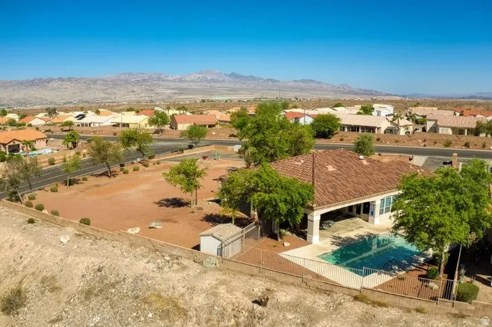 Tiled-roof residence featuring a private swimming pool, covered patio, and desert-adapted landscaping