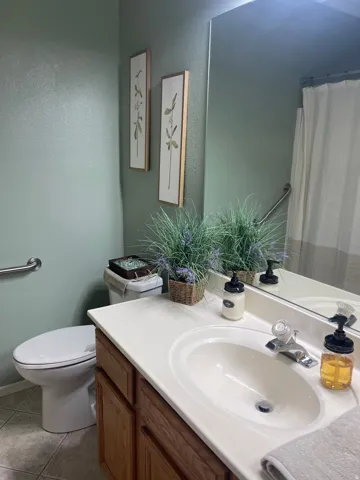 Bathroom vanity with an integrated white sink, chrome faucet, and wood-finish cabinetry