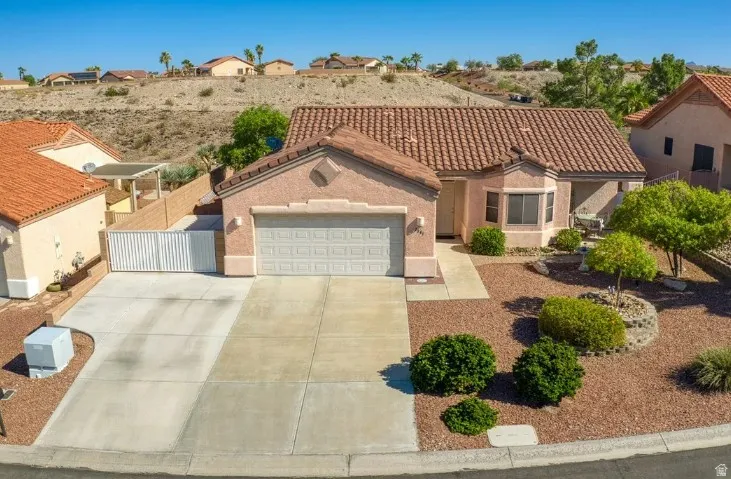 Stucco exterior featuring a tiled roof and an integrated two-car garage