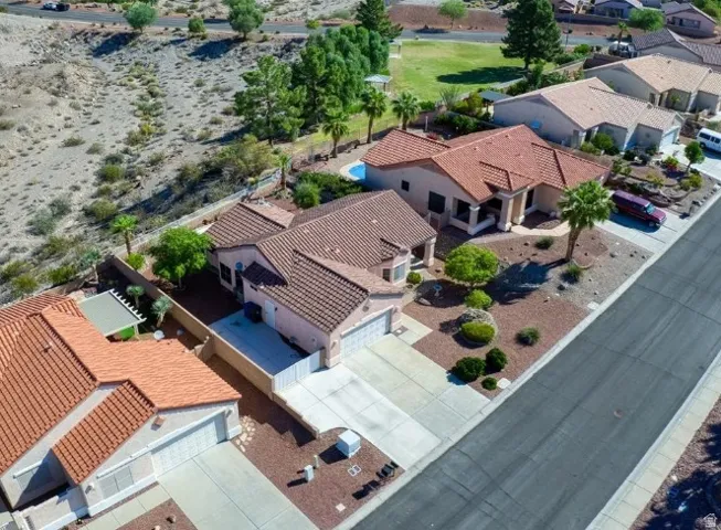 Southwestern-style residence featuring a terracotta tile roof, attached garage, and mature desert landscaping