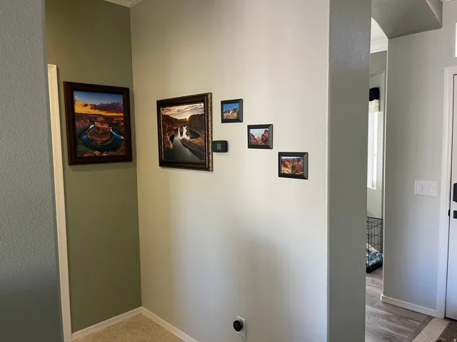 Hallway featuring an arched entryway, two-tone wall paint, and tile flooring