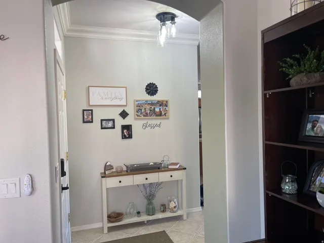 Archway entry featuring crown molding, recessed lighting, and tile flooring
