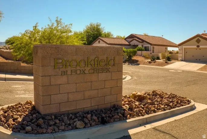 Community entrance sign crafted from brick and stone, featuring decorative lettering