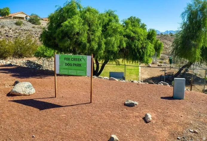 Fox Creek Dog Park entrance featuring red aggregate ground cover