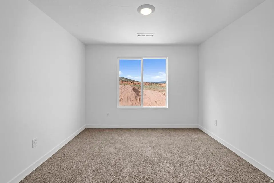 Spacious room with plush carpeting and crisp white walls