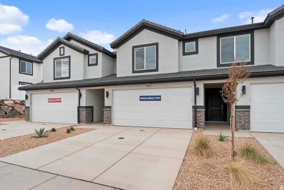 Contemporary multi-unit exterior featuring light-toned stucco and dark trim accents