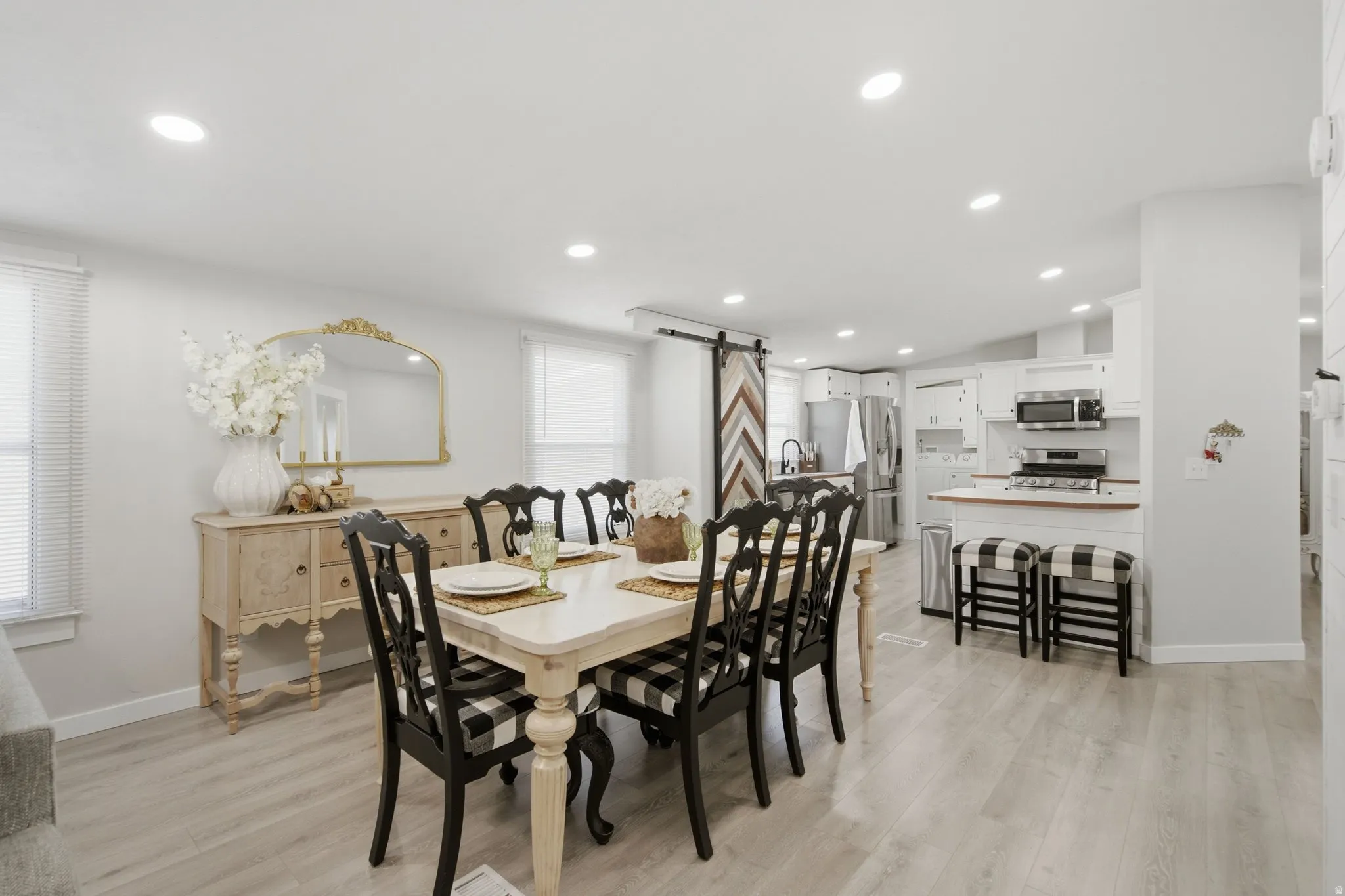 Open-concept living space featuring wood-finish flooring, recessed lighting, and white walls