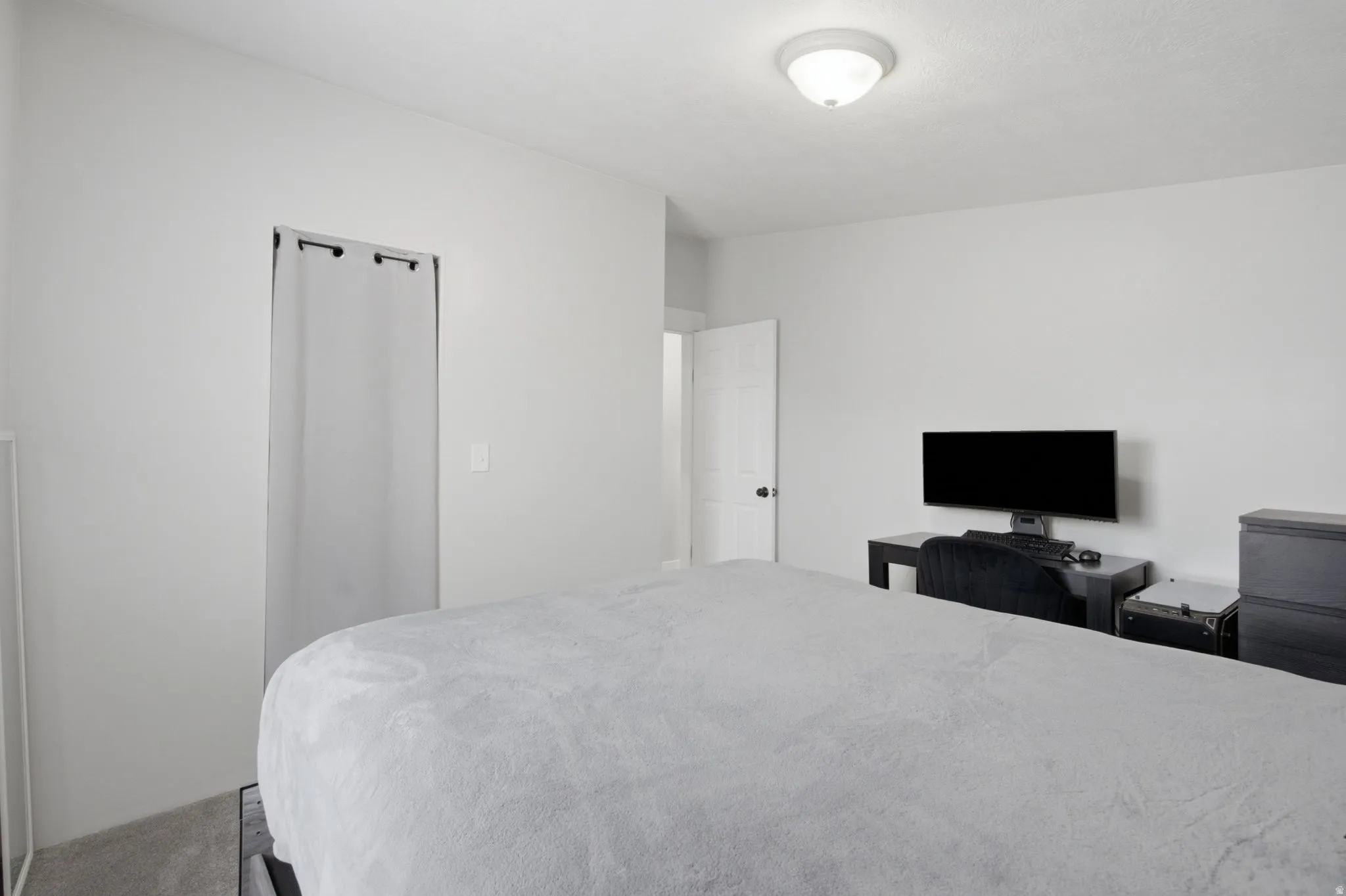Bedroom featuring light gray wall paint, a flush-mount ceiling light fixture, and gray carpet flooring