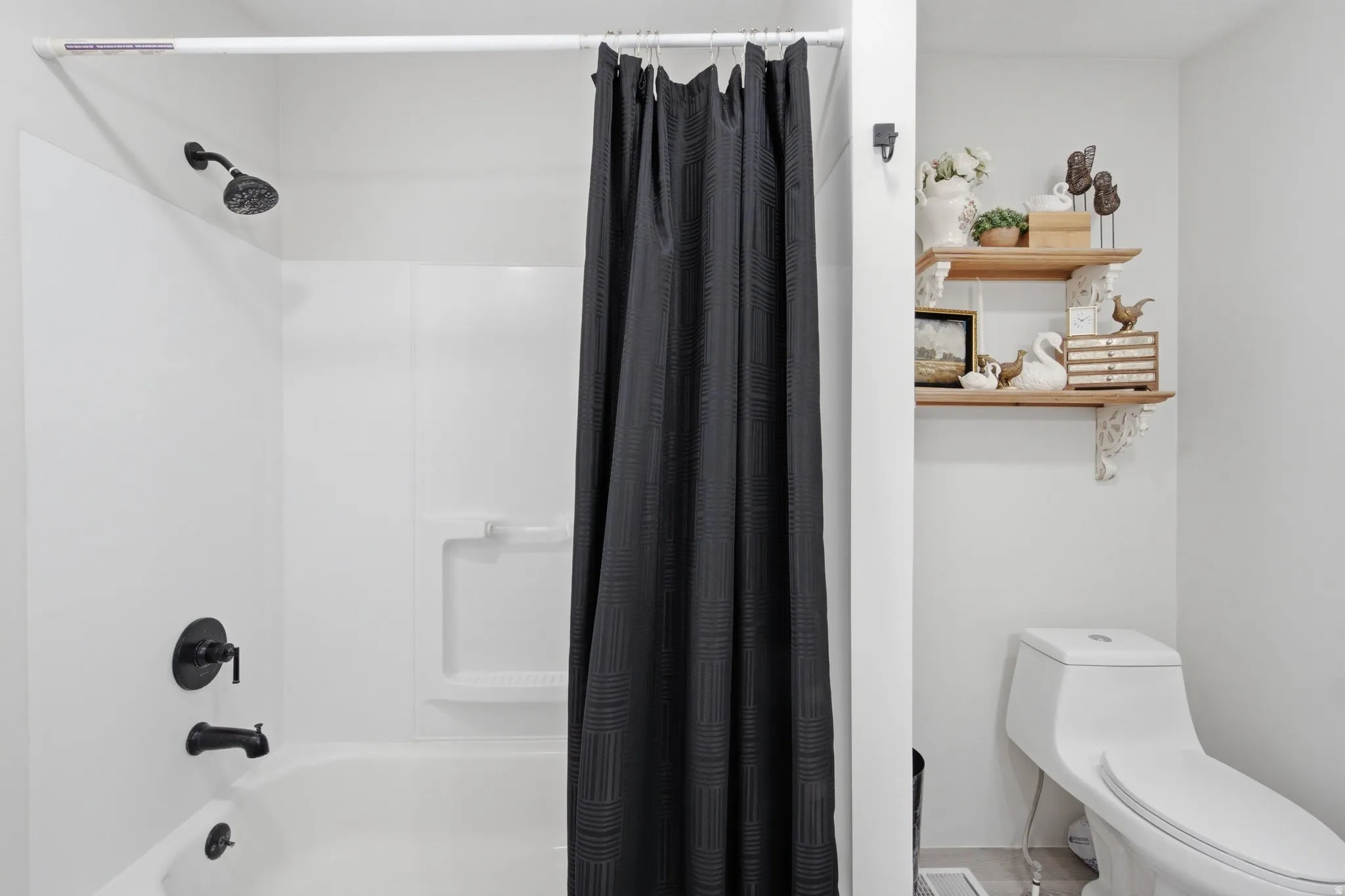 White tub/shower combination with matte black fixtures